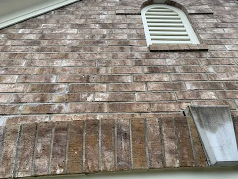 Horizontal and vertical cracks in a brick wall above an arched window requiring professional repair.