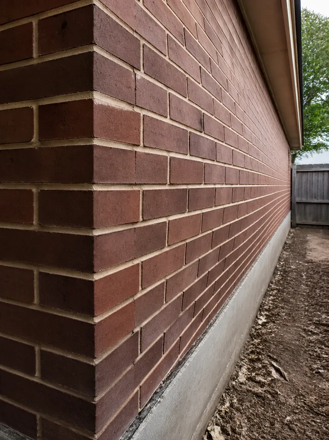 Bowing brick wall showing structural masonry failure due to foundation settlement in Dallas.