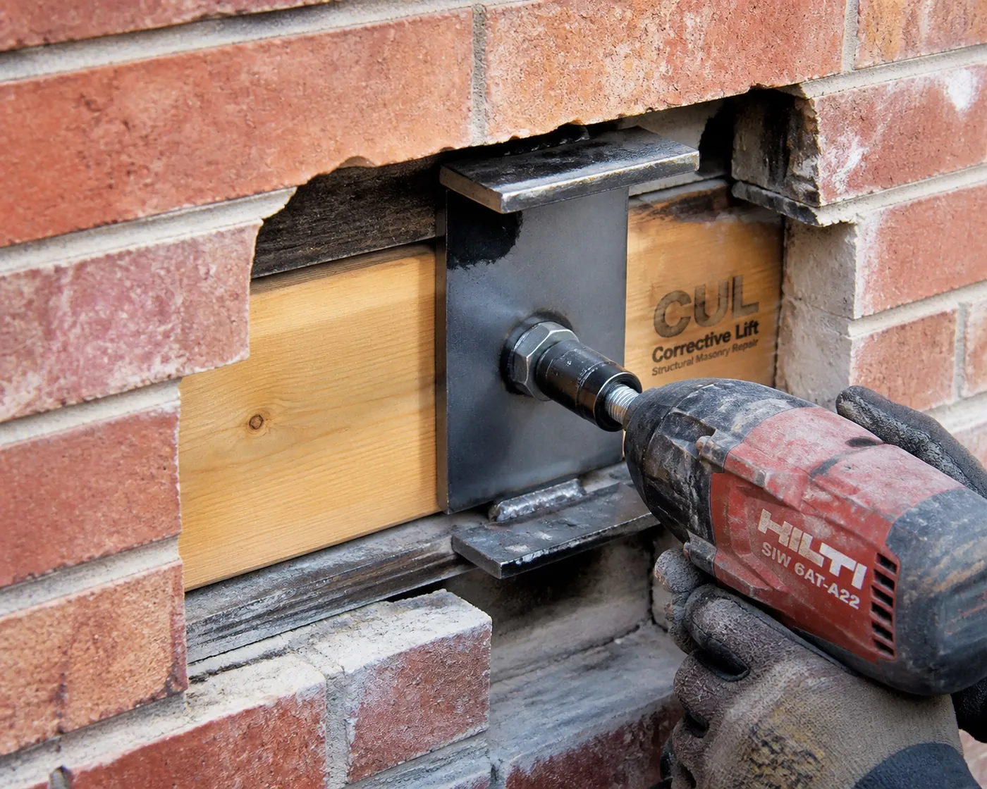 Professional installation of LintelLOCK structural hardware to secure a garage lintel and prevent rotational sagging.
