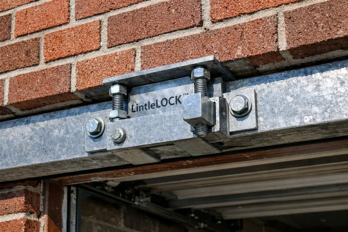 Close-up of LintelLOCK™ hardware installed in a brick garage header for permanent structural masonry repair.